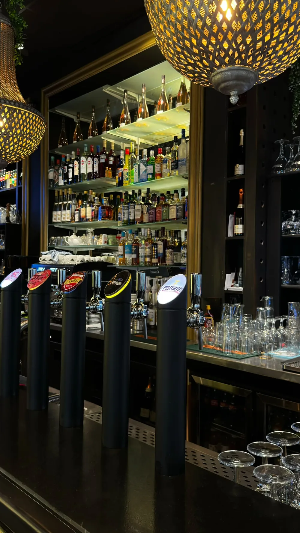 Le bar de La Cathédrale, ses tireuses et ses étagères de spiritueux