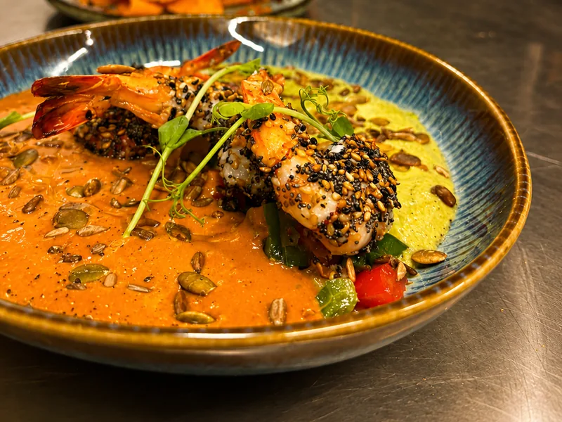 Gambas en croûte de sésame et pavot, bisque et purée d'herbes